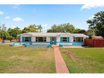 Charming single-story home featuring a brick walkway, turquoise accents, and a well-manicured lawn at 4421 28Th N Ave, St Petersburg, FL 33713
