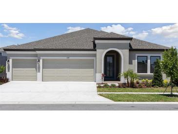 Beautiful single Gathering home featuring a two car garage, manicured lawn and modern architectural details at 5194 Everlong Dr, Apollo Beach, FL 33572