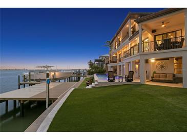 Elegant backyard with a private dock, luxury pool, manicured lawn, and an entertainment area overlooking the water at 5939 Bayview S Cir, Gulfport, FL 33707