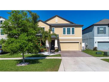 Charming two-story home with a tan exterior, well-manicured lawn, and inviting curb appeal at 13651 Ashlar Slate Pl, Riverview, FL 33579