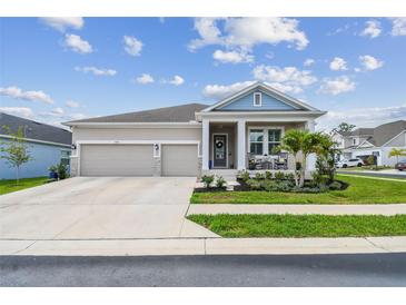 Charming single-story home featuring a manicured lawn, stone accents and a two-car garage at 1499 Gopher Loop, Tarpon Springs, FL 34689