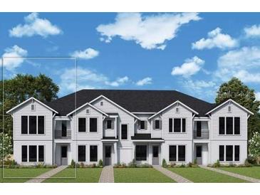 New two-story townhome featuring symmetrical design, multiple windows, and manicured lawn at 1631 Springwell Ln, Sarasota, FL 34240