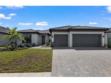 Beautiful single-story home featuring a two-car garage, manicured landscaping, and a neutral color palette at 1797 Pepper Grass Dr, North Port, FL 34289