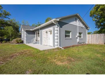 Charming stucco home featuring updated windows, a gray paint scheme, and a well-maintained lawn at 267 Broad St, Brooksville, FL 34604