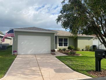 Charming home with a two-car garage, tidy landscaping, and an American flag displayed outside at 29436 Zeller Ave, San Antonio, FL 33576