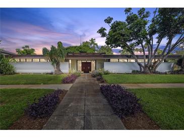 Stunning mid-century modern home featuring lush landscaping and a symmetrical facade at 3501 S Drexel Ave, Tampa, FL 33629