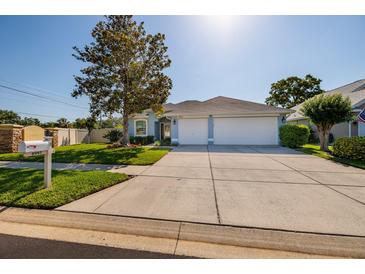 Charming single-story home with well-maintained landscaping, a spacious driveway, and a two-car garage at 4997 W Breeze Cir, Palm Harbor, FL 34683