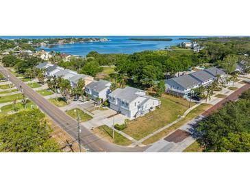 An aerial view of a neighborhood with waterfront access featuring townhouses and a view of the bay at 581 Oceanview Ave, Palm Harbor, FL 34683