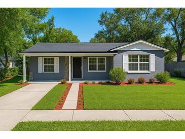 Charming home featuring a well-manicured lawn, stone accents, and a welcoming entrance at 10931 110Th Ave, Seminole, FL 33778