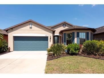 Charming single-story home featuring a well-manicured lawn and a two-car garage, great curb appeal at 16313 Treasure Point Dr, Wimauma, FL 33598