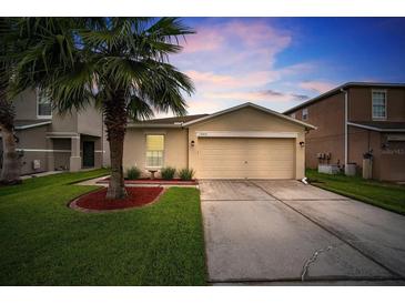 Charming single-story home featuring a well-manicured lawn and attached two-car garage at 17413 Garden Heath Ct, Land O Lakes, FL 34638