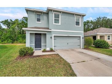 Charming two-story home with a gray exterior, two-car garage, and well-maintained landscaping at 32775 Brooks Hawk Ln, Wesley Chapel, FL 33543
