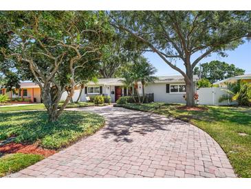 Charming single-story home featuring a brick driveway, lush landscaping, and inviting curb appeal at 430 44Th Ne Ave, St Petersburg, FL 33703