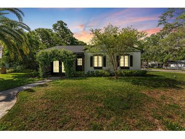 Charming single-story home with a well-manicured lawn and an inviting, plant-covered archway entrance at 433 San Salvador Dr, Dunedin, FL 34698
