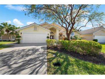 Charming single-story home boasts lush landscaping, mature trees, and a well-maintained two-car garage and inviting entrance at 5290 White Sand Ne Cir, St Petersburg, FL 33703
