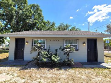 Charming single-story home featuring two front doors, secure window bars, and a neatly landscaped yard at 5401 E 14Th Ave, Tampa, FL 33619
