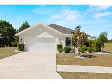 Charming single-story home with a well-manicured lawn, mature trees, and an attached two-car garage at 7061 Lamium Ct, Brooksville, FL 34602