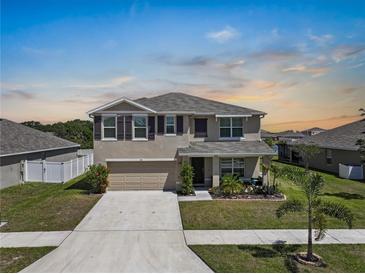 Charming two-story home featuring a well-manicured lawn and inviting curb appeal at 718 Tidal Rock Ave, Ruskin, FL 33570