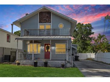 Charming two-story home with a front porch and second story balcony, plus a red front door at 757 32Nd N Ave, St Petersburg, FL 33704