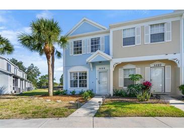 Charming townhome featuring a light blue exterior, white trim, and lush landscaping at 5084 Misty Canal Pl, Bradenton, FL 34203