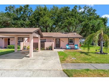 Charming single-story home with a covered parking area, and colorful chairs on the front lawn at 7203 55Th N Ave, St Petersburg, FL 33709