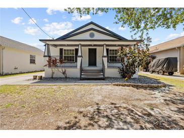 Charming single-story home with a covered front porch and a well-manicured yard at 7509 S West Shore Blvd, Tampa, FL 33616