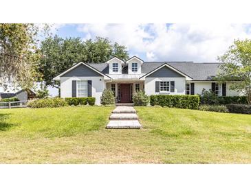 Charming home with a well-manicured lawn, symmetrical landscaping, and inviting brick pathway to the front door at 812 Jameson Rd, Lithia, FL 33547