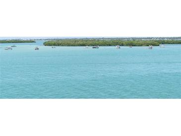 Scenic waterfront view showcasing turquoise water, lush islands, and leisure boats enjoying a day out on the water at 1 Key Capri # 303E, Treasure Island, FL 33706