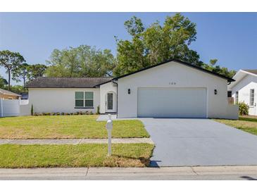 Charming single-story home with a well-manicured lawn, paved driveway, and an attached two-car garage at 104 Meadowcross Dr, Safety Harbor, FL 34695