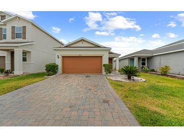 Charming single-story home with a well-manicured lawn and a brick-paved driveway leading to the garage at 11819 Brighton Knoll Loop, Riverview, FL 33579