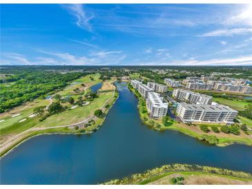 Beautiful aerial view overlooking a golf course, lake, and modern condo buildings on a sunny day at 1200 Country Club Dr # 5506, Largo, FL 33771