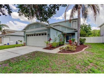 Charming two-story home with a well-manicured lawn, complemented by lush landscaping and a welcoming entrance at 12628 White Bluff Rd, Hudson, FL 34669