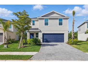 Charming two-story home with a blue garage door and beautifully landscaped front yard at 13981 Lilac Sky Ter, Bradenton, FL 34211