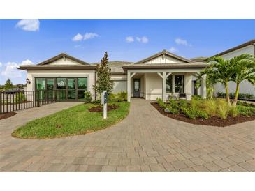 Charming single-story home featuring a brick driveway, manicured lawn, and covered entryway at 16411 Sapphire Point Dr, Lakewood Ranch, FL 34211