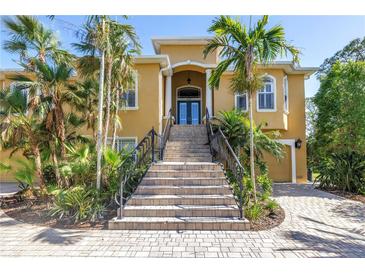 Stately two-story home with lush landscaping and a grand staircase leading to the entryway at 2101 N Pointe Alexis Dr, Tarpon Springs, FL 34689
