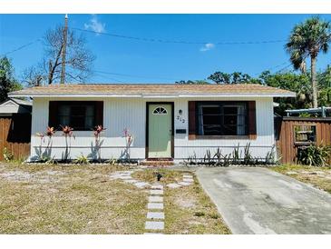 Charming home with a light green door, stone pathway, and landscaped yard at 212 41St S St, St Petersburg, FL 33711