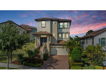 Elegant two-story home featuring landscaped yard, brick driveway, and covered entryway at 3585 Torino Ln, Palm Harbor, FL 34683