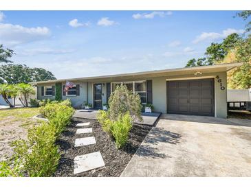Charming single-story home featuring a well-maintained yard and attached garage with mature landscaping at 4610 W Mcelroy Ave, Tampa, FL 33611
