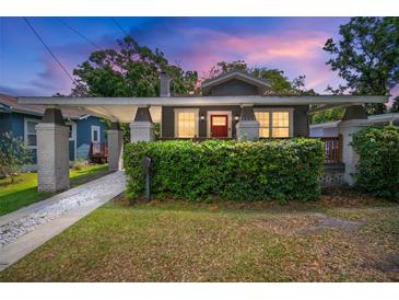 Charming bungalow featuring a cozy front porch, brick pillars and lush green hedge at 4803 Highland, Tampa, FL 33603