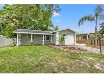 Charming home featuring a lush lawn, mature trees, and a one-car garage at 5245 3Rd N Ave, St Petersburg, FL 33710