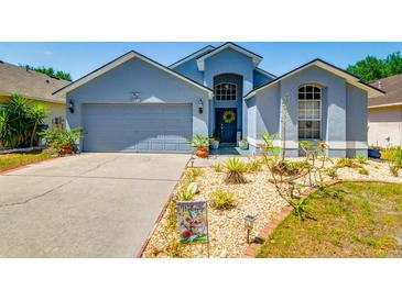 Charming single-Gathering home featuring a 2-car garage and beautifully landscaped front yard, complete with a welcoming wreath on the door at 7132 Colony Pointe Dr, Riverview, FL 33578