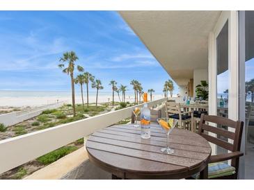 Enjoy ocean views from the spacious balcony with seating and beautiful palm trees at 17900 Gulf Blvd # 1B, Redington Shores, FL 33708