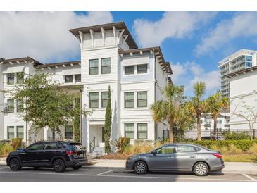 Beautiful three-story townhome with white facade, decorative tower, and manicured landscaping at 5351 Bridge St # 9, Tampa, FL 33611