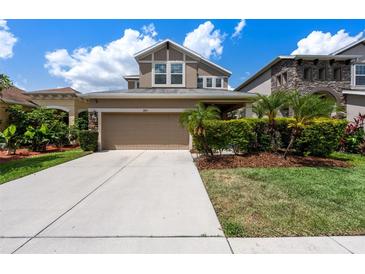 Charming two-story home with landscaped yard and a spacious two car garage at 7699 Windchase Way, Wesley Chapel, FL 33545