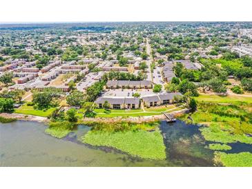 Wide aerial view of the community buildings near a lake, lush greenery, and scenic surroundings at 10100 Sailwinds N Blvd # 105, Largo, FL 33773