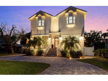 Stunning two-story home with brick paved driveway, lush landscaping, and illuminated exterior at 2303 S Occident St, Tampa, FL 33629