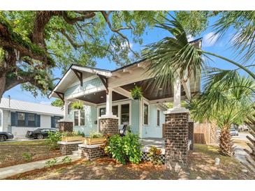 Charming craftsman-style home featuring a covered front porch with brick pillars and lush landscaping at 3008 N 13Th St, Tampa, FL 33605