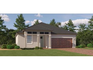 Charming single-story home with a brick driveway, lush lawn, and a two-car garage at 31826 Griffin Sands Ln, San Antonio, FL 33576