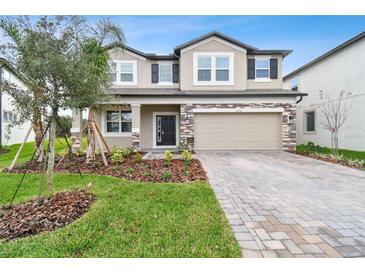 Charming two-story home with stone accents, manicured landscaping, and a paved driveway at 38190 Shale Stone Ct, Zephyrhills, FL 33540