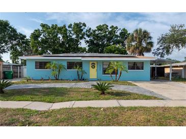 Charming home featuring a tidy front yard, new driveway, and bright yellow front door at 4721 W Iowa Ave, Tampa, FL 33616